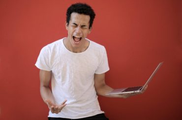 young ethnic male with laptop screaming