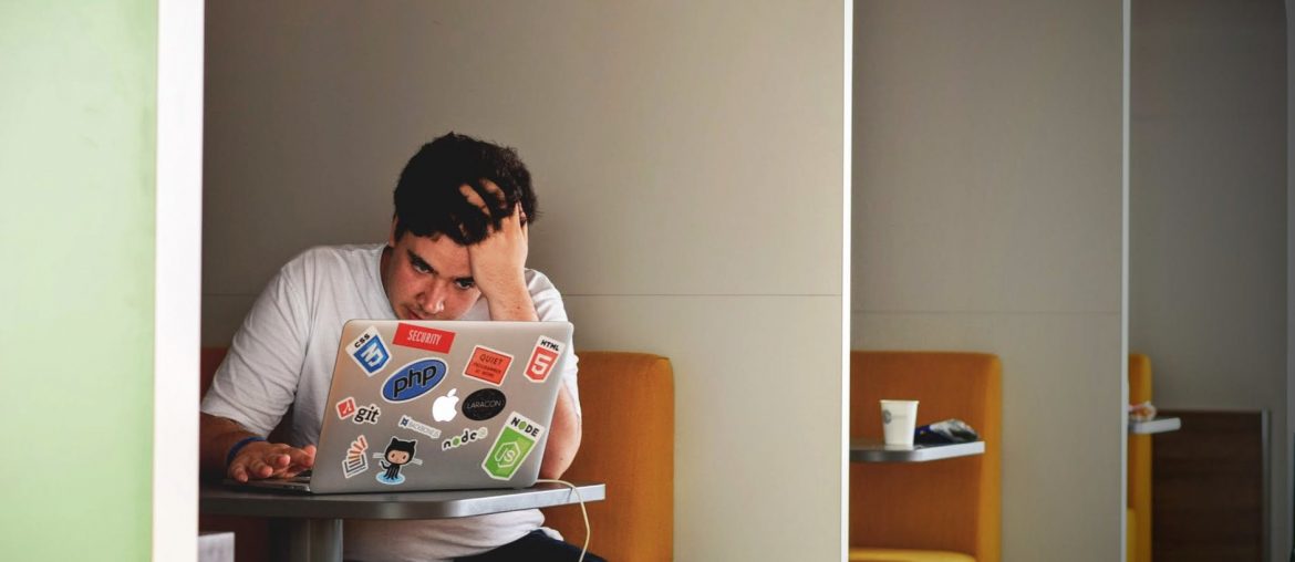 man in white shirt using macbook pro